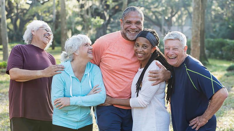 senior group of friends hugging outdoors